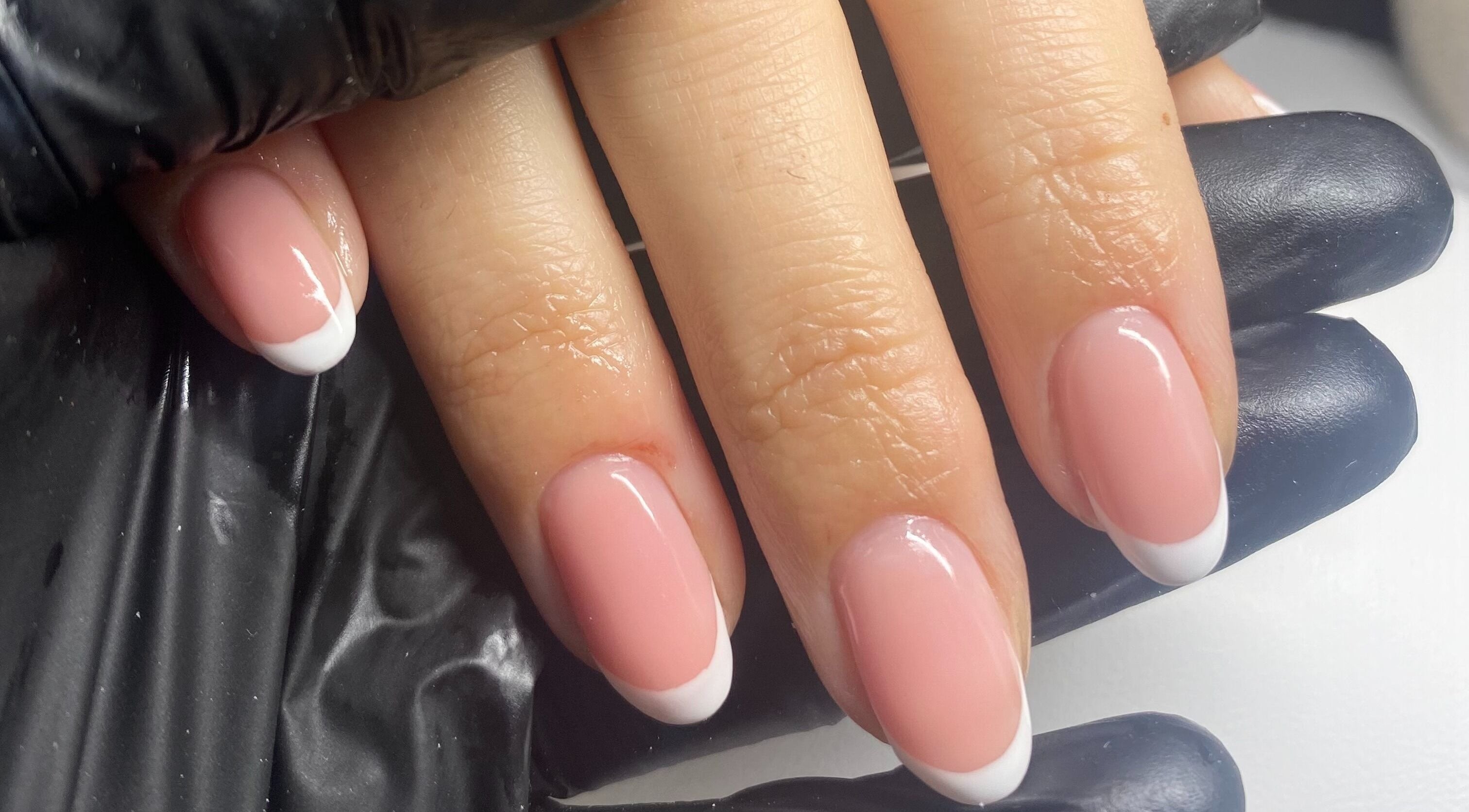 Elegant French manicure at Cure The Nail Studio, Oswestry, England, GB, showcasing glossy pink nails with white tips.