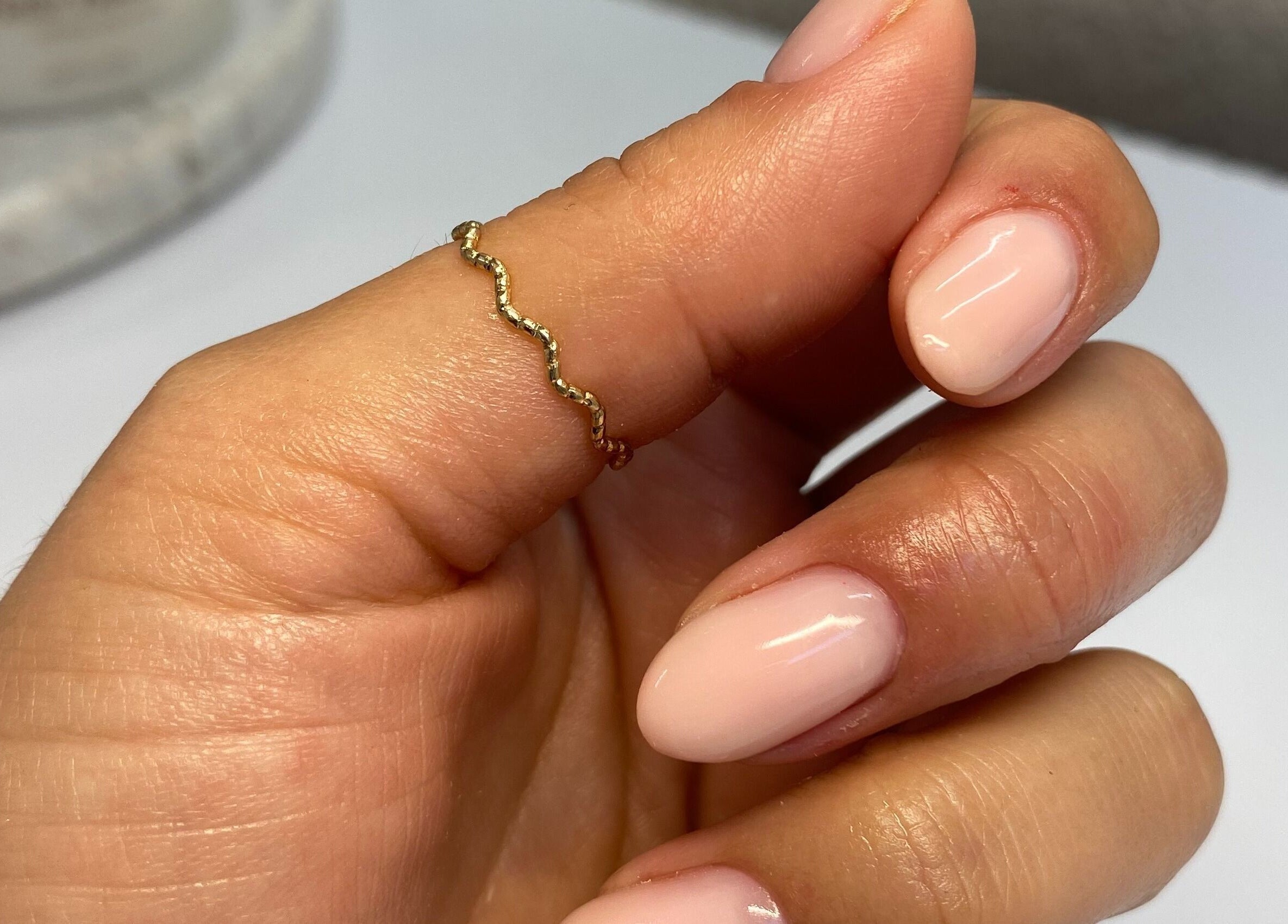 Elegant manicured nails with a gold ring at Cure The Nail Studio, Oswestry, England, GB.