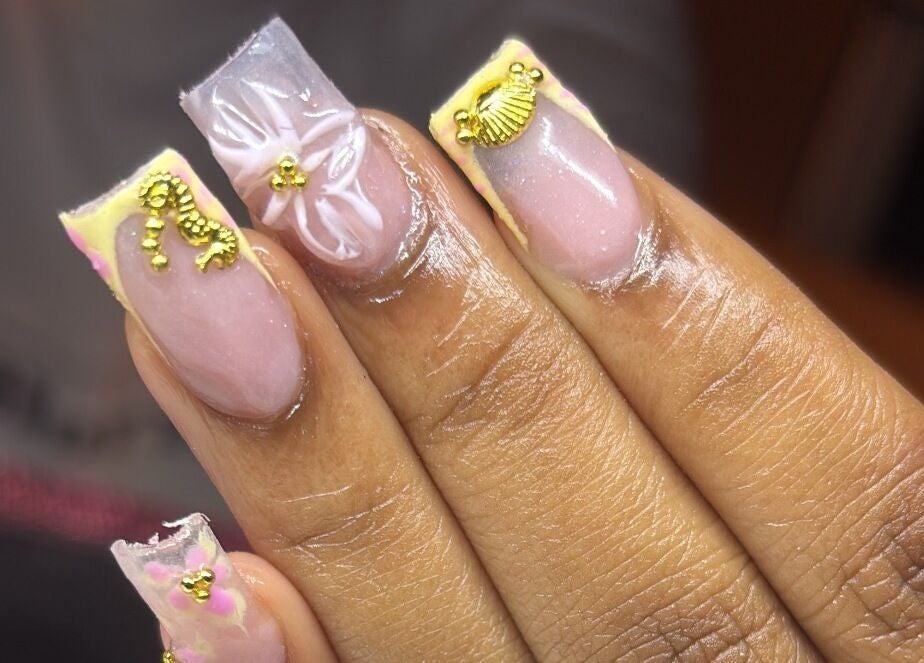 Elegant nail art at SquaredByT, Cole Bay, Sint Maarten, SX featuring gold decor and floral designs.