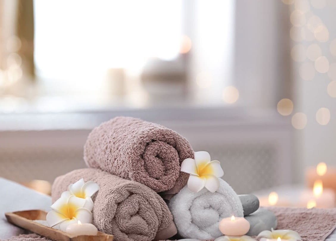 Oba Massage in Jacksonville, Florida, offers a tranquil scene with towels, flowers, and candles for ultimate relaxation.