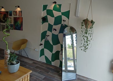 Interior de Akua Luna Nail Art Studio en Luquillo, PR, con espejo decorativo y arte mural moderno.