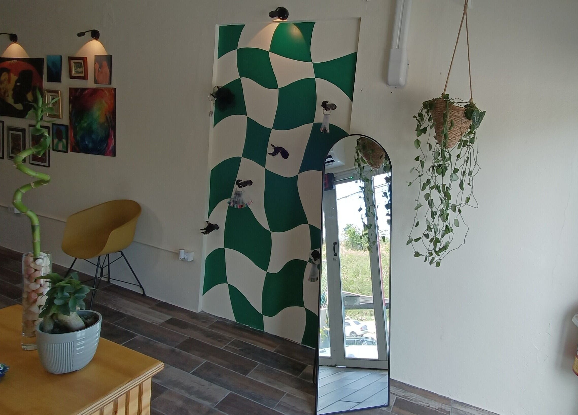 Interior de Akua Luna Nail Art Studio en Luquillo, PR, con espejo decorativo y arte mural moderno.