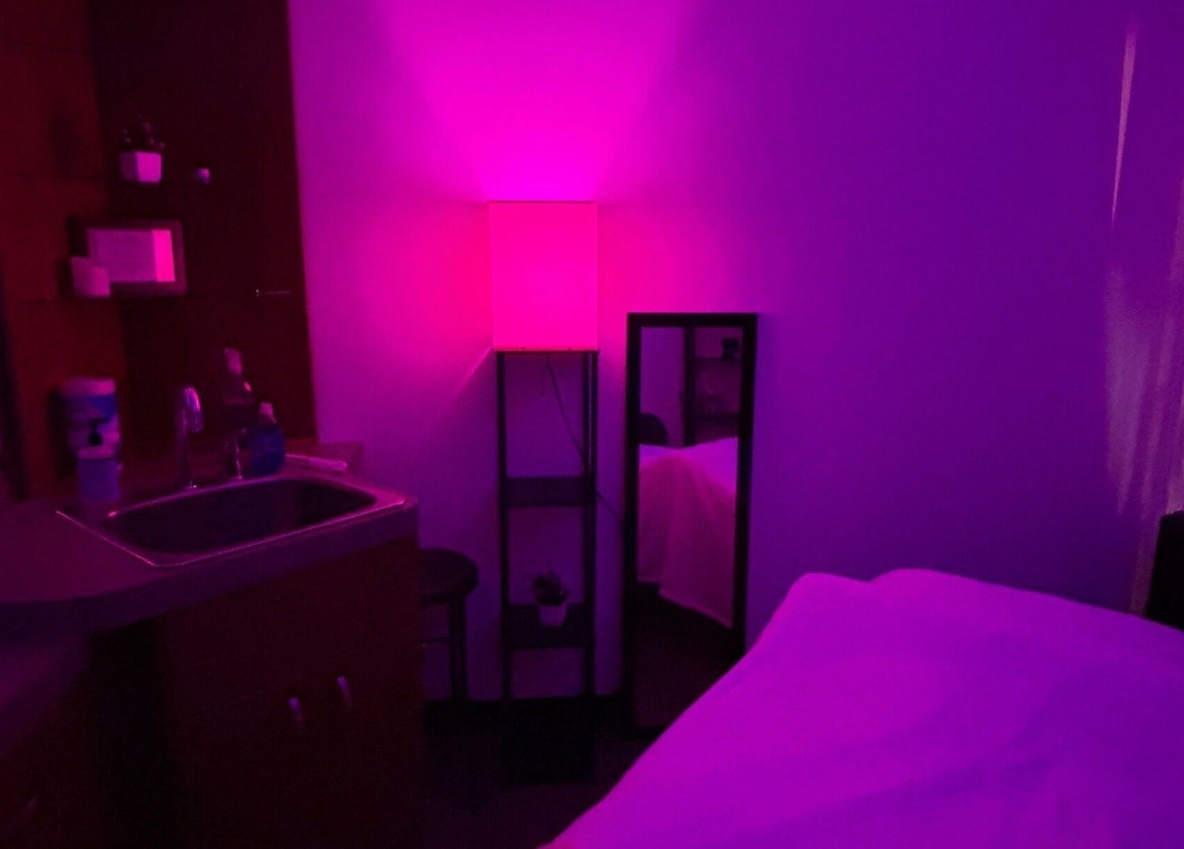 Soothing massage room at Moore Magic Massage, North Little Rock, Arkansas, US, with ambient purple lighting.
