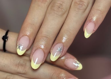 Elegant yellow french nails with star design at The Nail Lounge, Barnsley, England, GB.