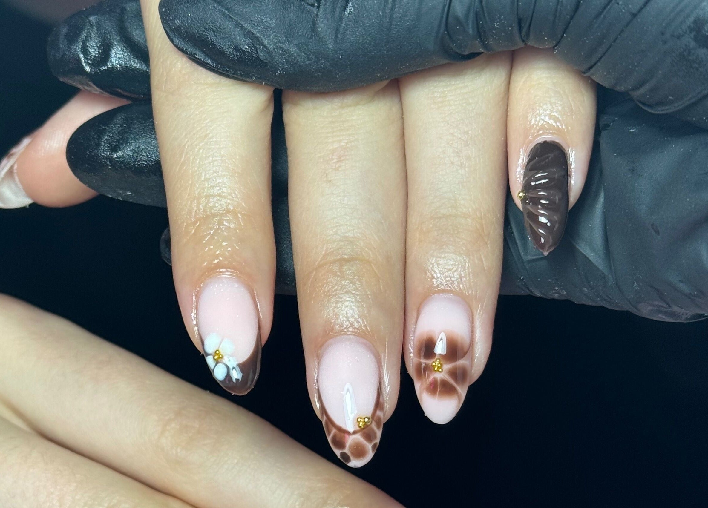 Intricate nail art featuring floral designs at The Nail Lounge, Barnsley, England, GB. Sophisticated hand styling.