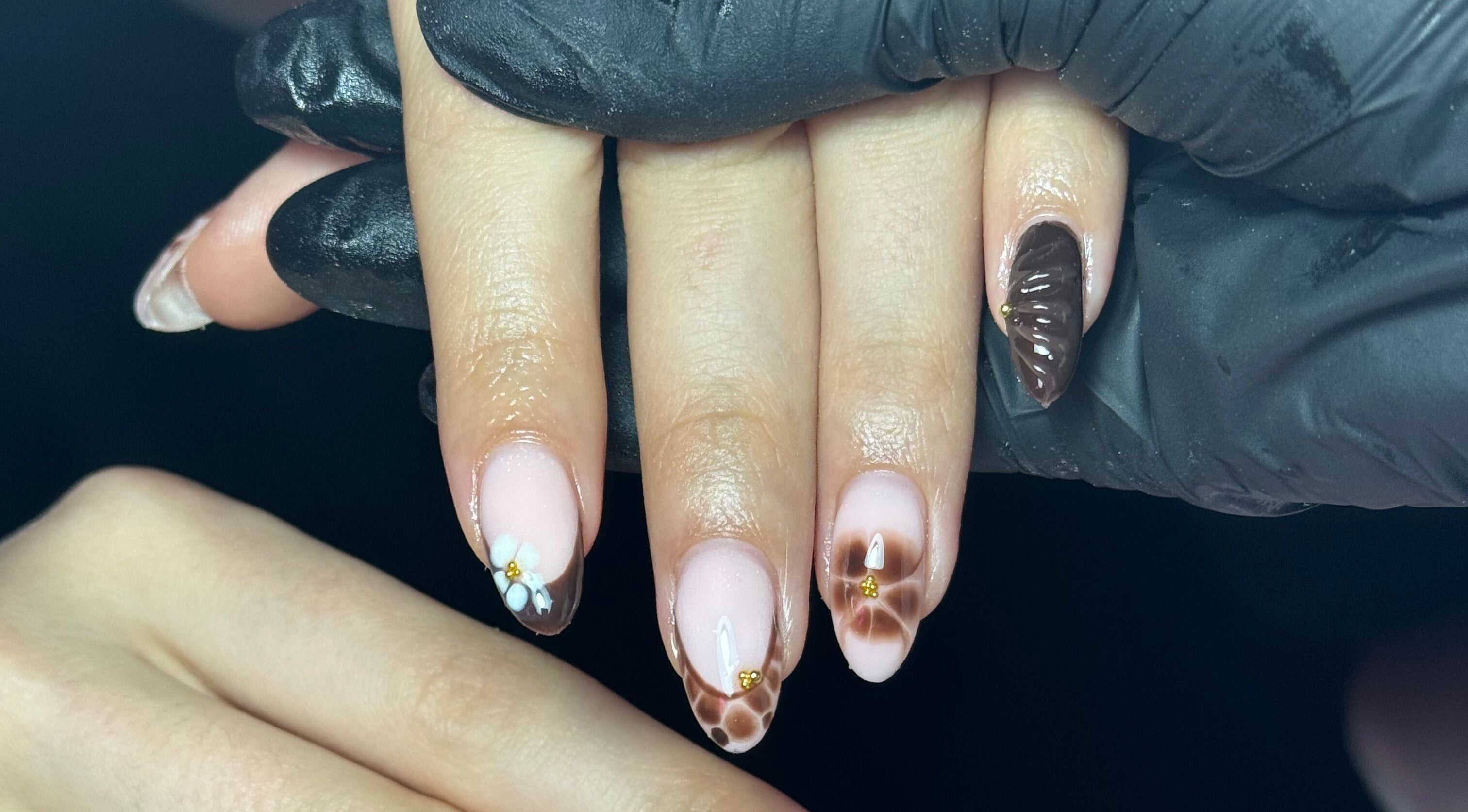 Intricate nail art featuring floral designs at The Nail Lounge, Barnsley, England, GB. Sophisticated hand styling.