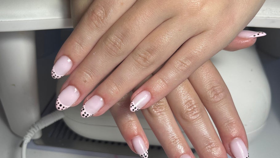 Chic pink nails with polka-dot tips at The Nail Room, Cliffsend, England, GB for stylish manicures.