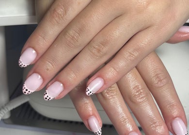 Chic pink nails with polka-dot tips at The Nail Room, Cliffsend, England, GB for stylish manicures.
