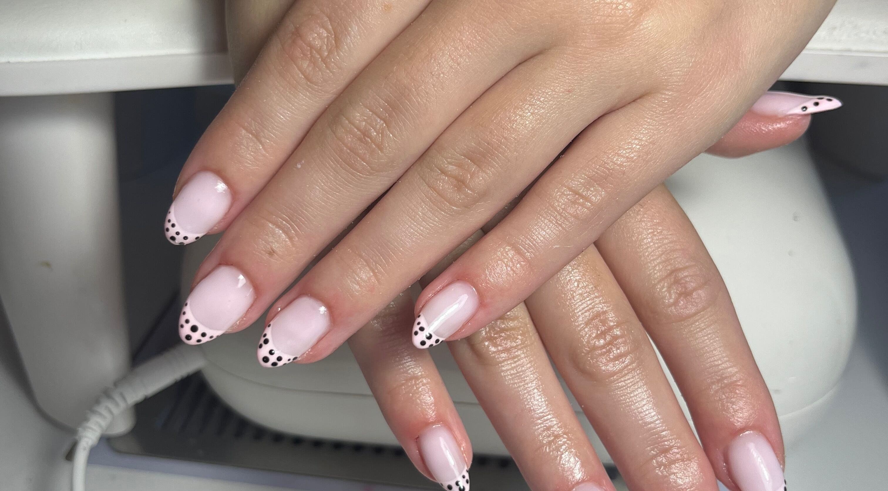 Chic pink nails with polka-dot tips at The Nail Room, Cliffsend, England, GB for stylish manicures.
