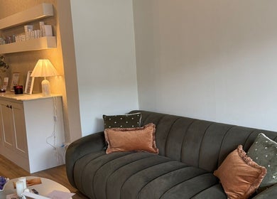 Inviting lounge area in Synergistic Therapy, Birmingham, England, GB with plush sofa and soft lighting.