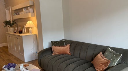 Inviting lounge area in Synergistic Therapy, Birmingham, England, GB with plush sofa and soft lighting.