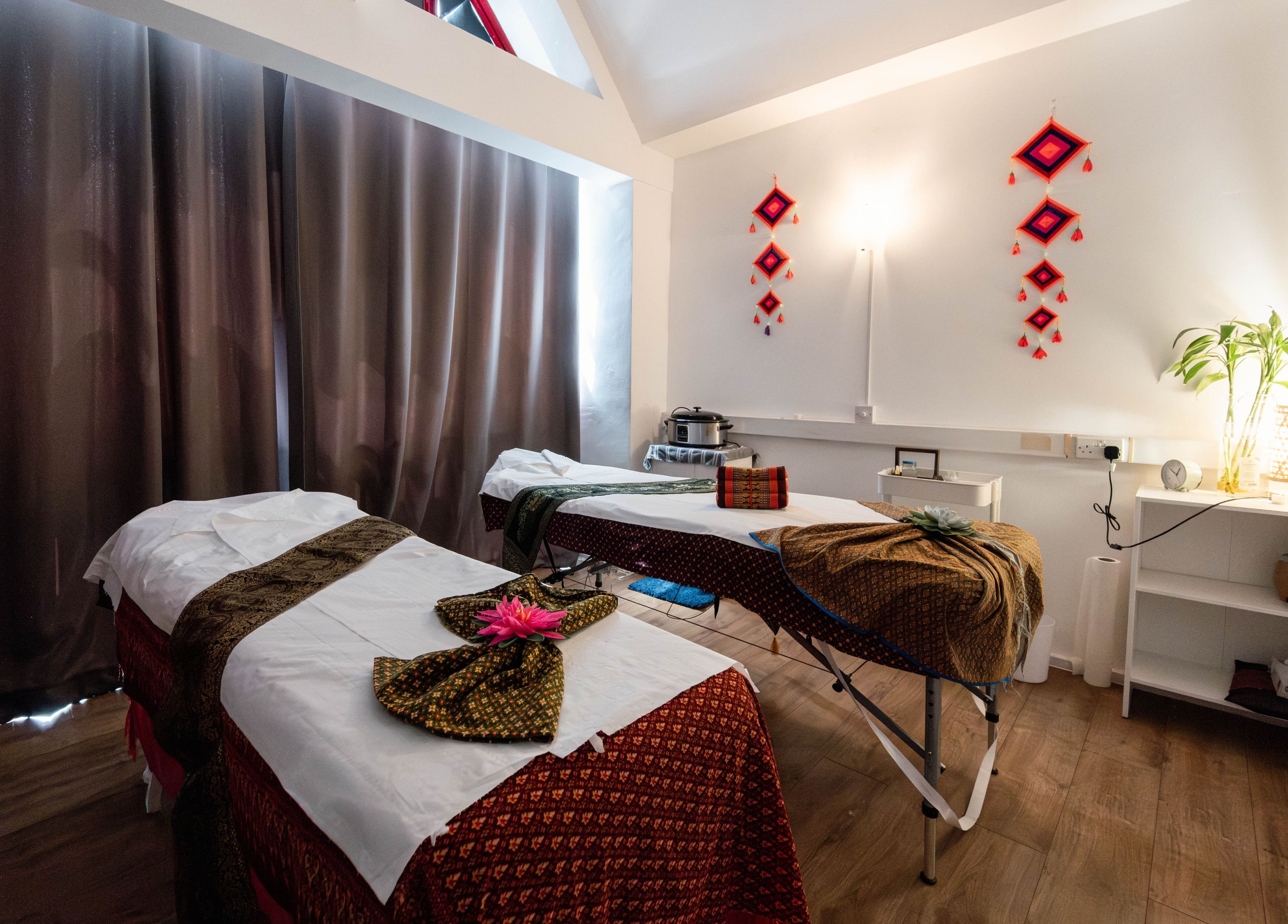 Serene massage room at Somchit Thai Massage and Spa, London, England, GB, featuring warm lighting and decor.