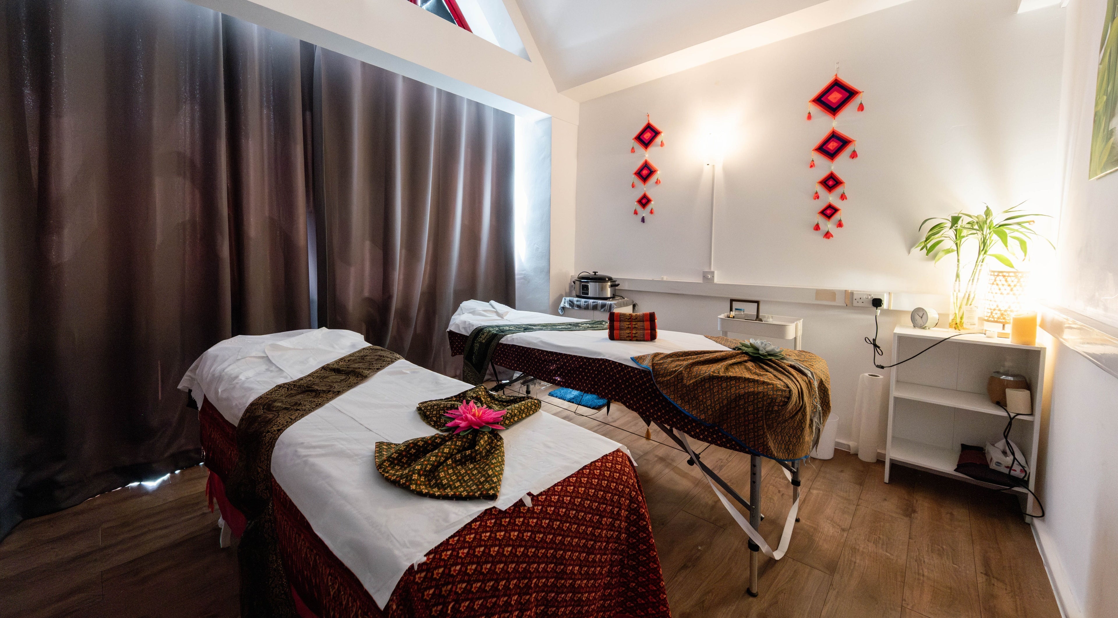 Serene massage room at Somchit Thai Massage and Spa, London, England, GB, featuring warm lighting and decor.