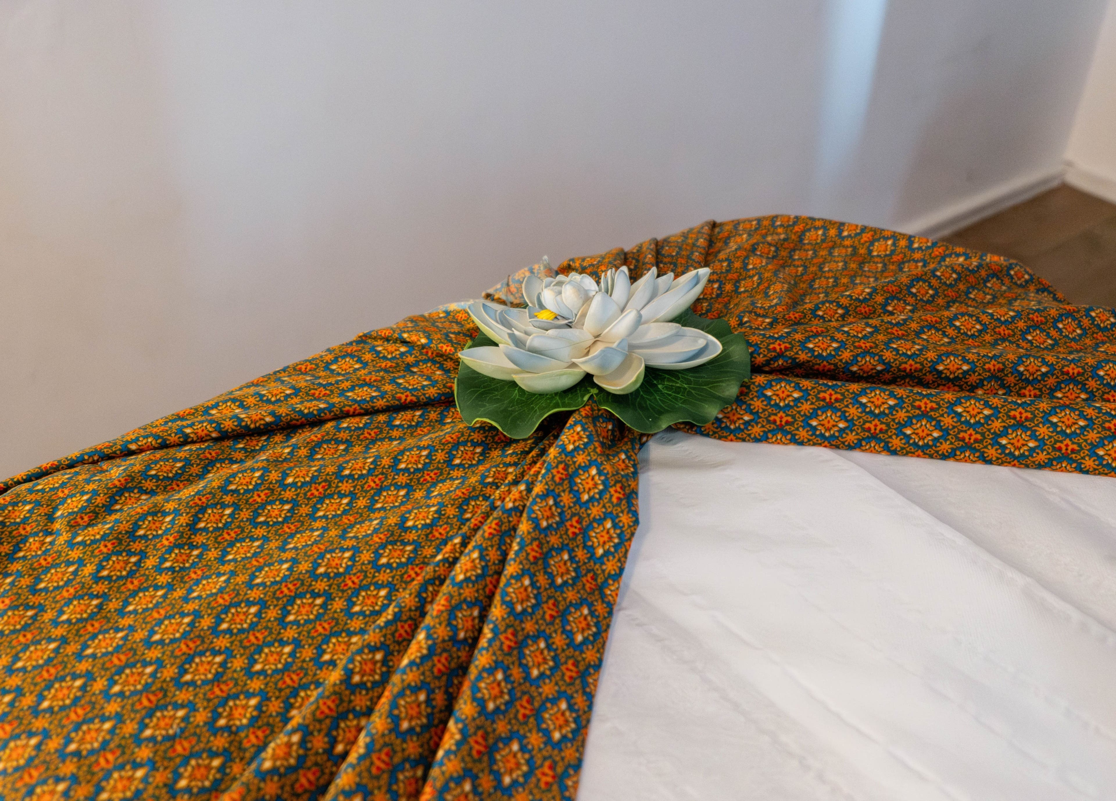 Elegant massage table setup at Somchit Thai Massage and Spa, London, England, GB with lotus flower decor.