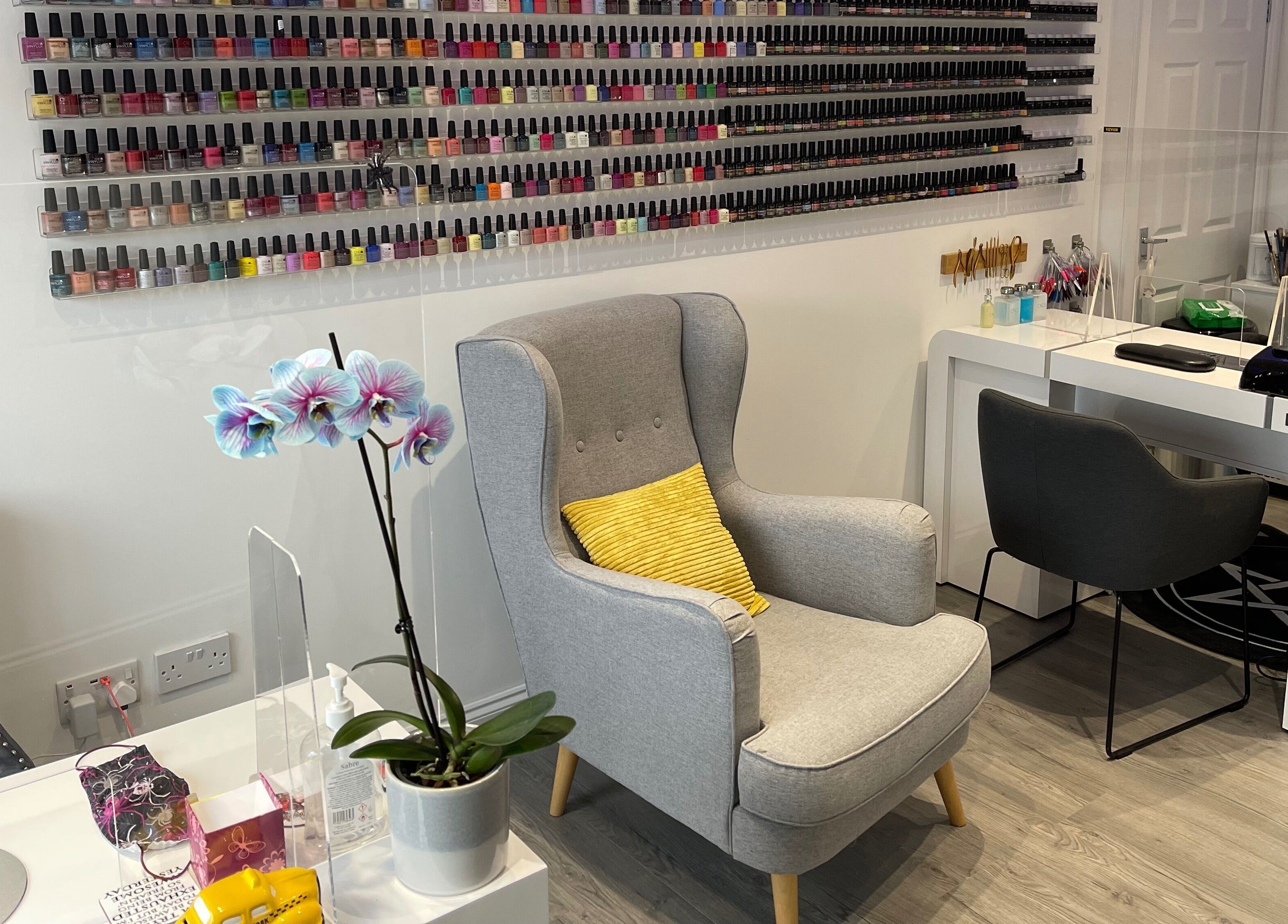 Chic nail salon interior at A Touch of Heaven, Kilbirnie, Scotland, GB with rows of nail polish and comfy seating.
