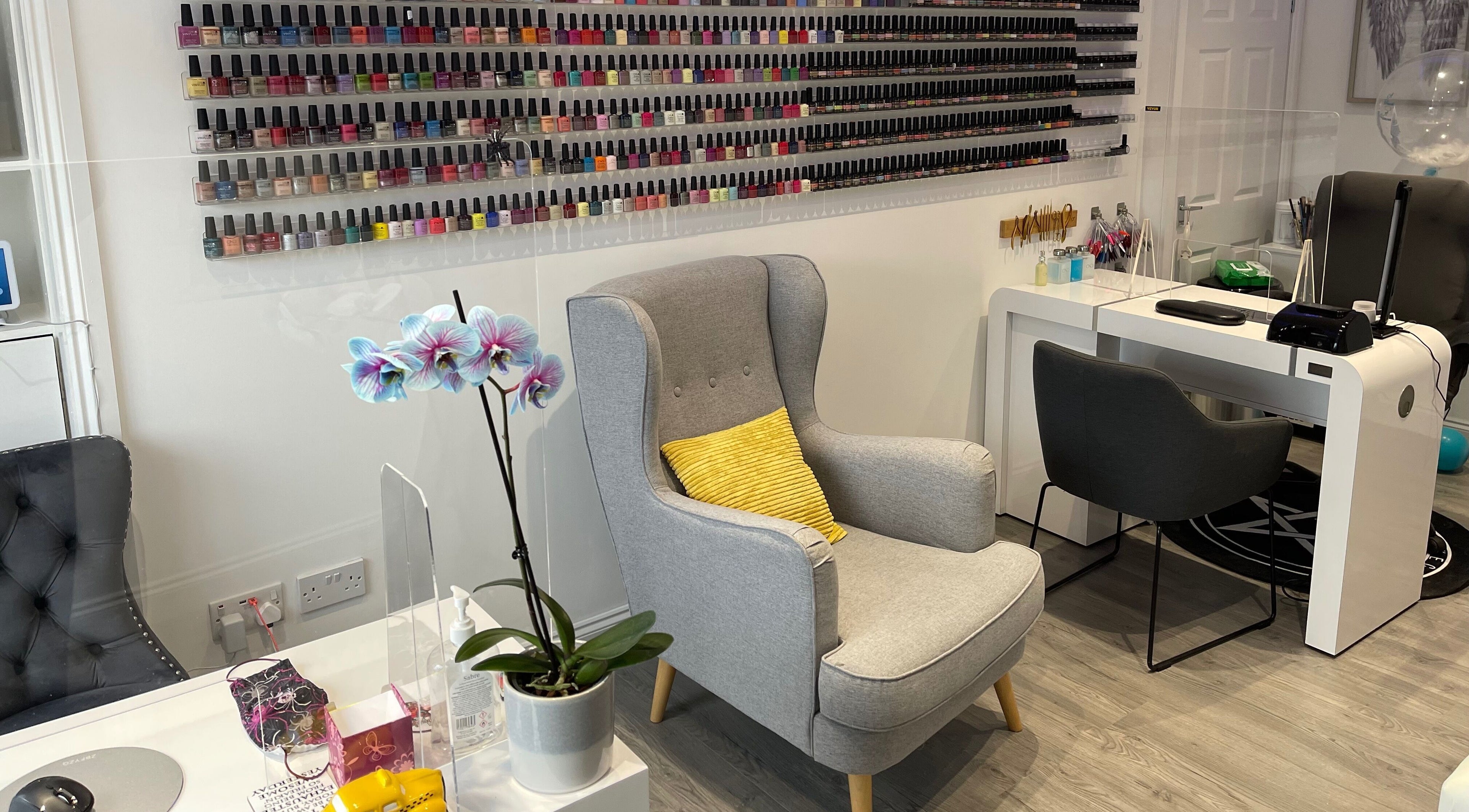 Chic nail salon interior at A Touch of Heaven, Kilbirnie, Scotland, GB with rows of nail polish and comfy seating.