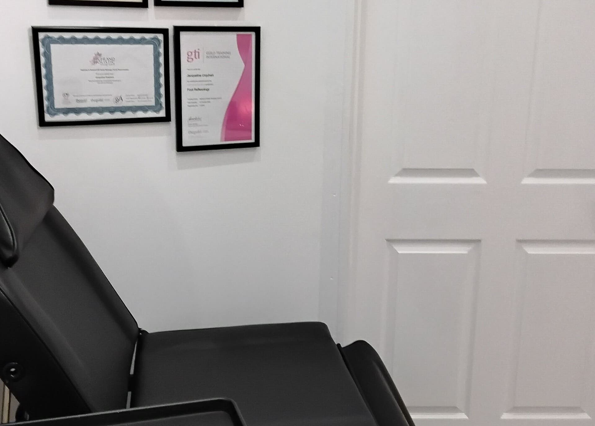 Comfortable treatment chair in Luxe Lounge, Dingwall, Scotland, GB adorned with professional certificates.