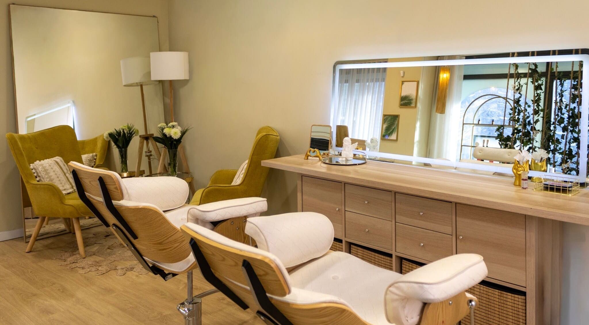 Interior moderno da Estética Isa Dias em Porto, Porto, PT, com cadeiras de design e espelho iluminado.