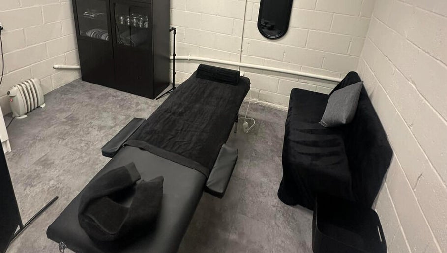 Calming massage room at A.J.Healing, South Ockendon, England, GB with a comfortable black treatment table.
