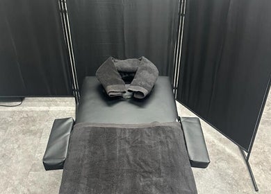 Massage table with black towels at A.J.Healing in South Ockendon, England, GB.