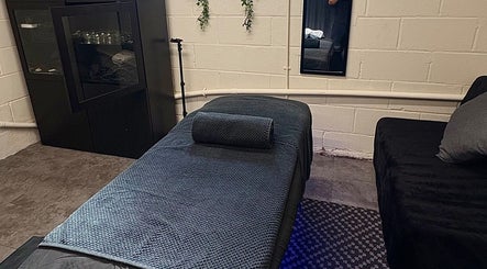 Tranquil massage room at A.J.Healing, South Ockendon, England, GB, featuring a cozy bed and gentle lighting.