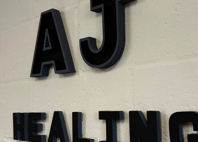 Close-up of A.J.Healing wall signage at South Ockendon, England, GB emphasizing wellness offerings.