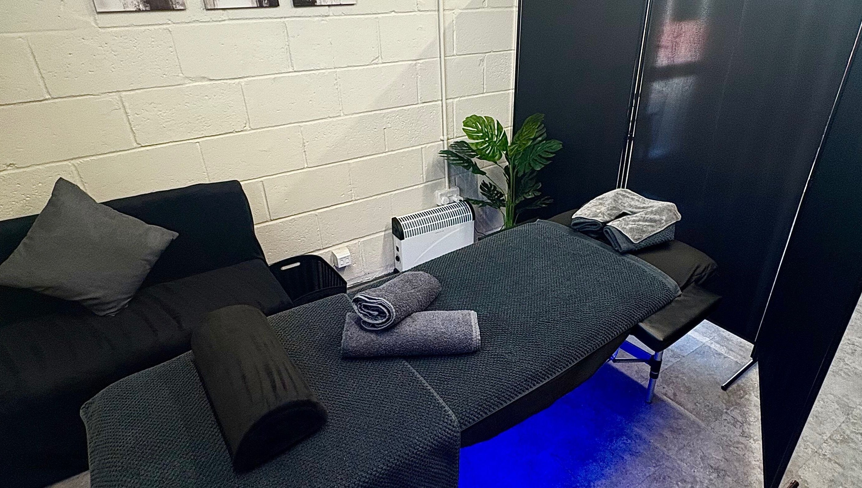 Cozy massage setup at A.J.Healing, South Ockendon, England, GB, featuring a cushioned table and elegant décor.