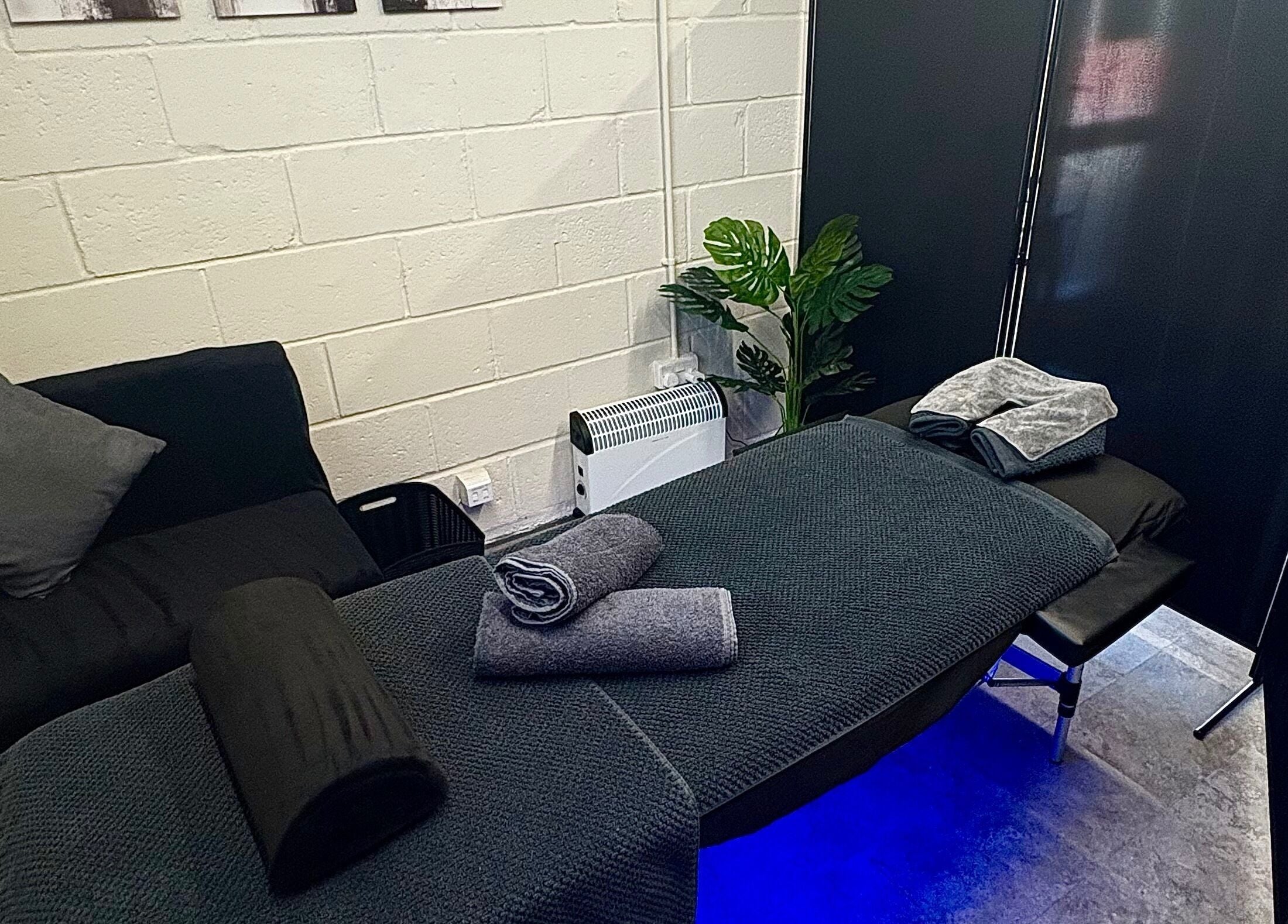 Cozy massage setup at A.J.Healing, South Ockendon, England, GB, featuring a cushioned table and elegant décor.