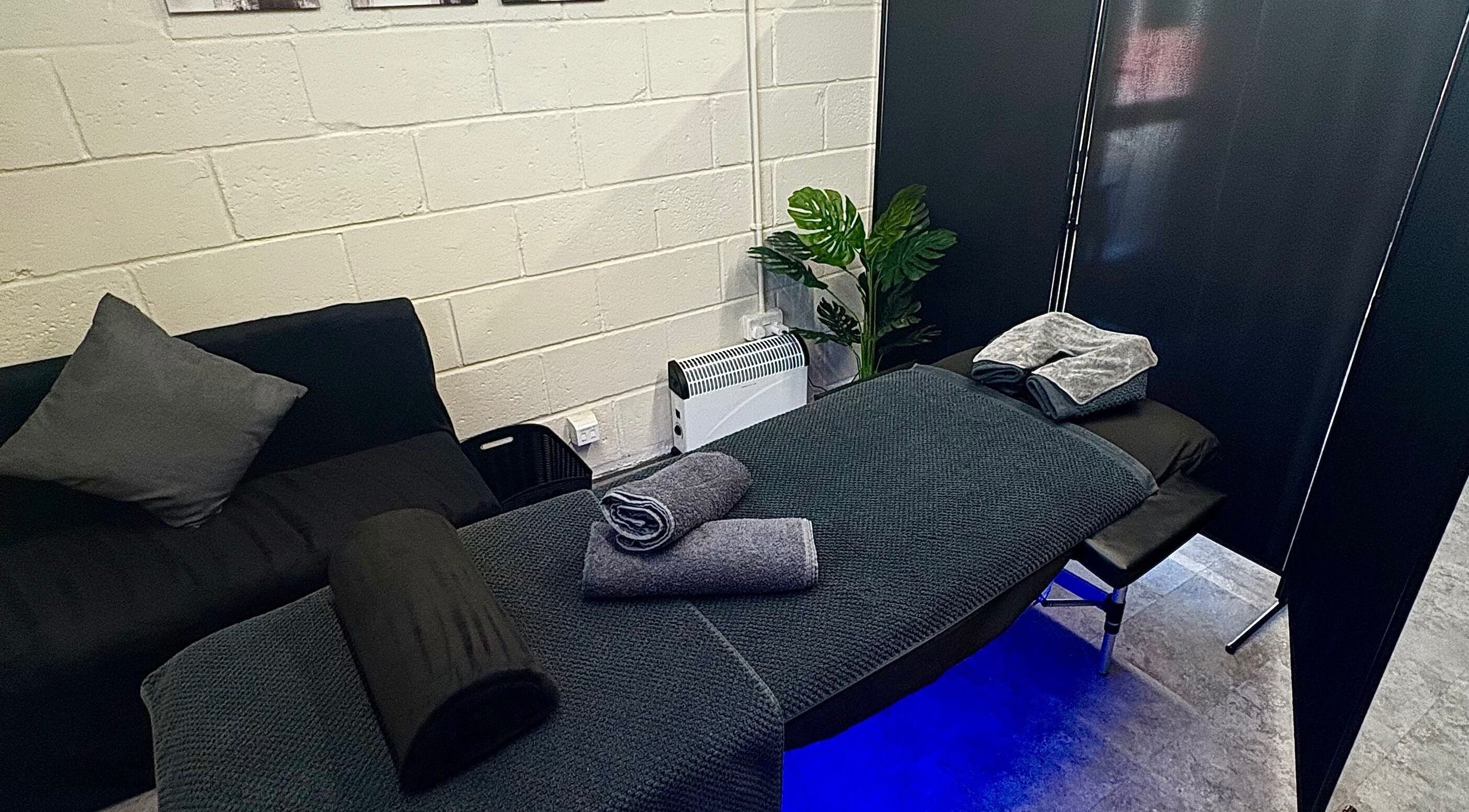 Cozy massage setup at A.J.Healing, South Ockendon, England, GB, featuring a cushioned table and elegant décor.