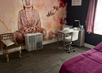 Peaceful treatment room at True Beauty, Forfar, Scotland, GB with a Buddha mural and cozy seating.