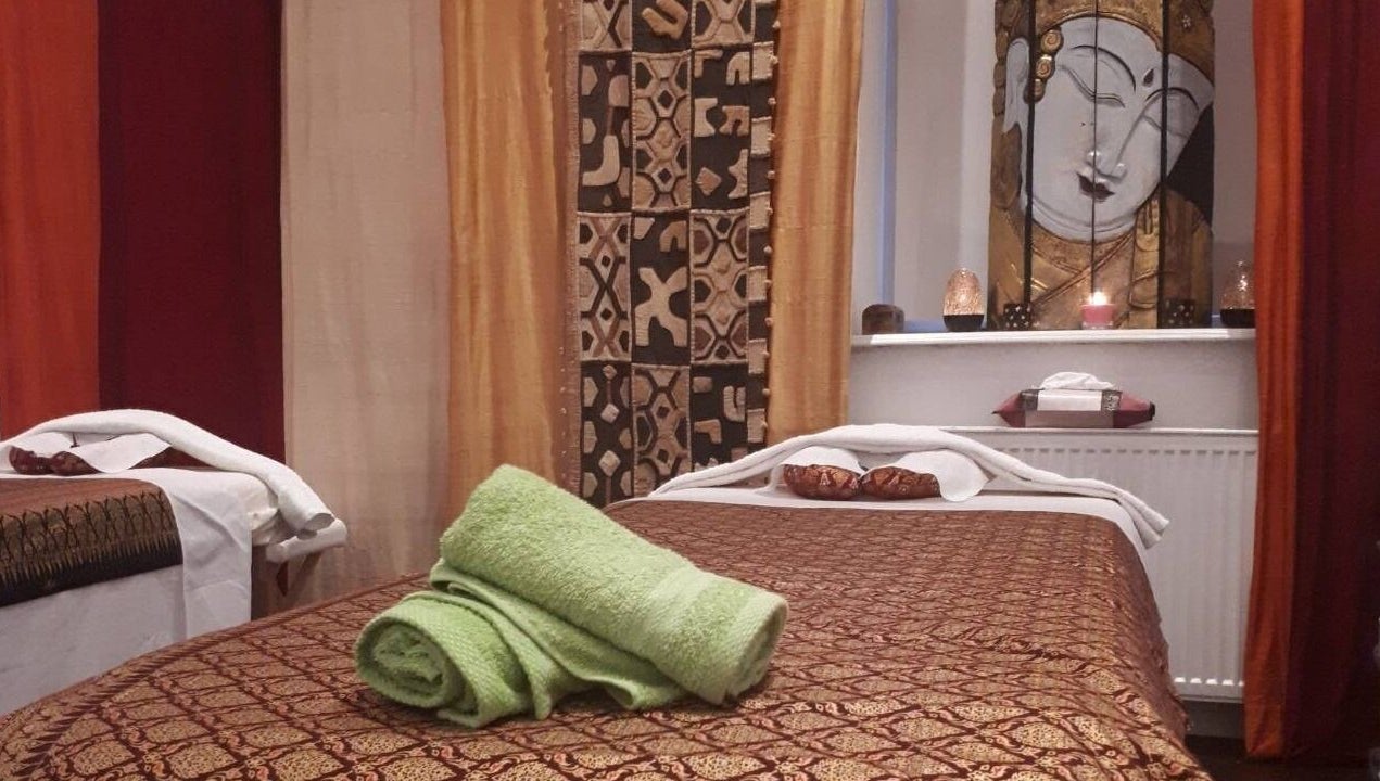 Ruhiger Massageraum bei Hi Spa 1 in Wien, Wien, AT. Entspanntes Ambiente mit Buddha-Dekor und Handtüchern.