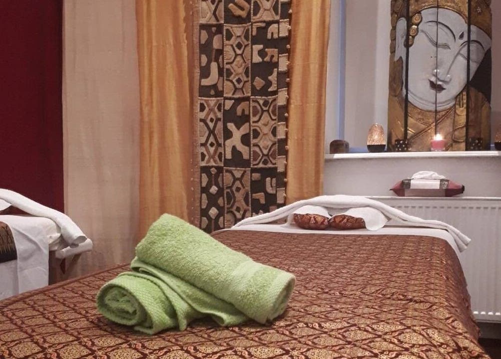 Ruhiger Massageraum bei Hi Spa 1 in Wien, Wien, AT. Entspanntes Ambiente mit Buddha-Dekor und Handtüchern.