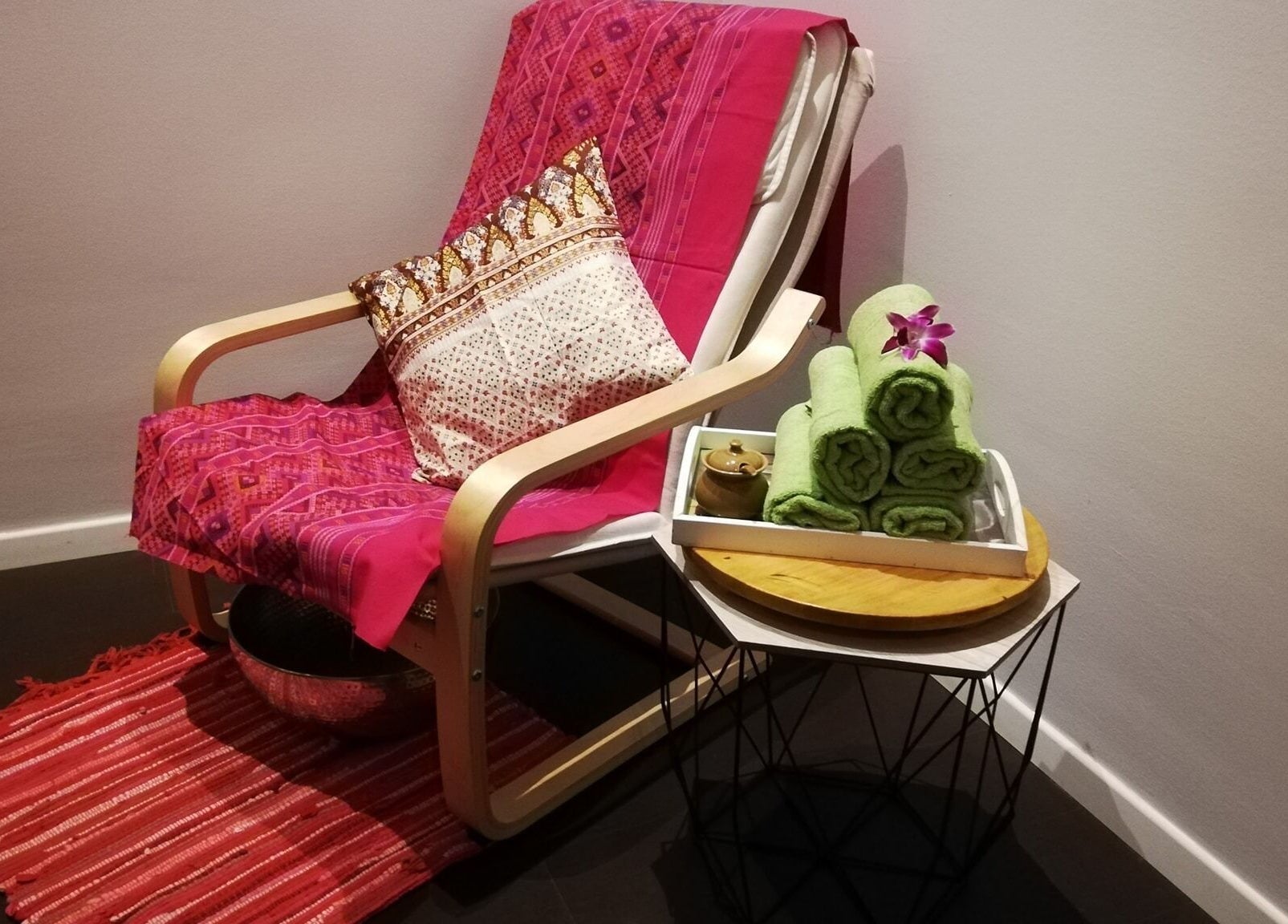 Gemütlicher Relax-Sessel bei Hi Spa 1, Wien, Wien, AT, mit pinker Decke und grünen Handtüchern.