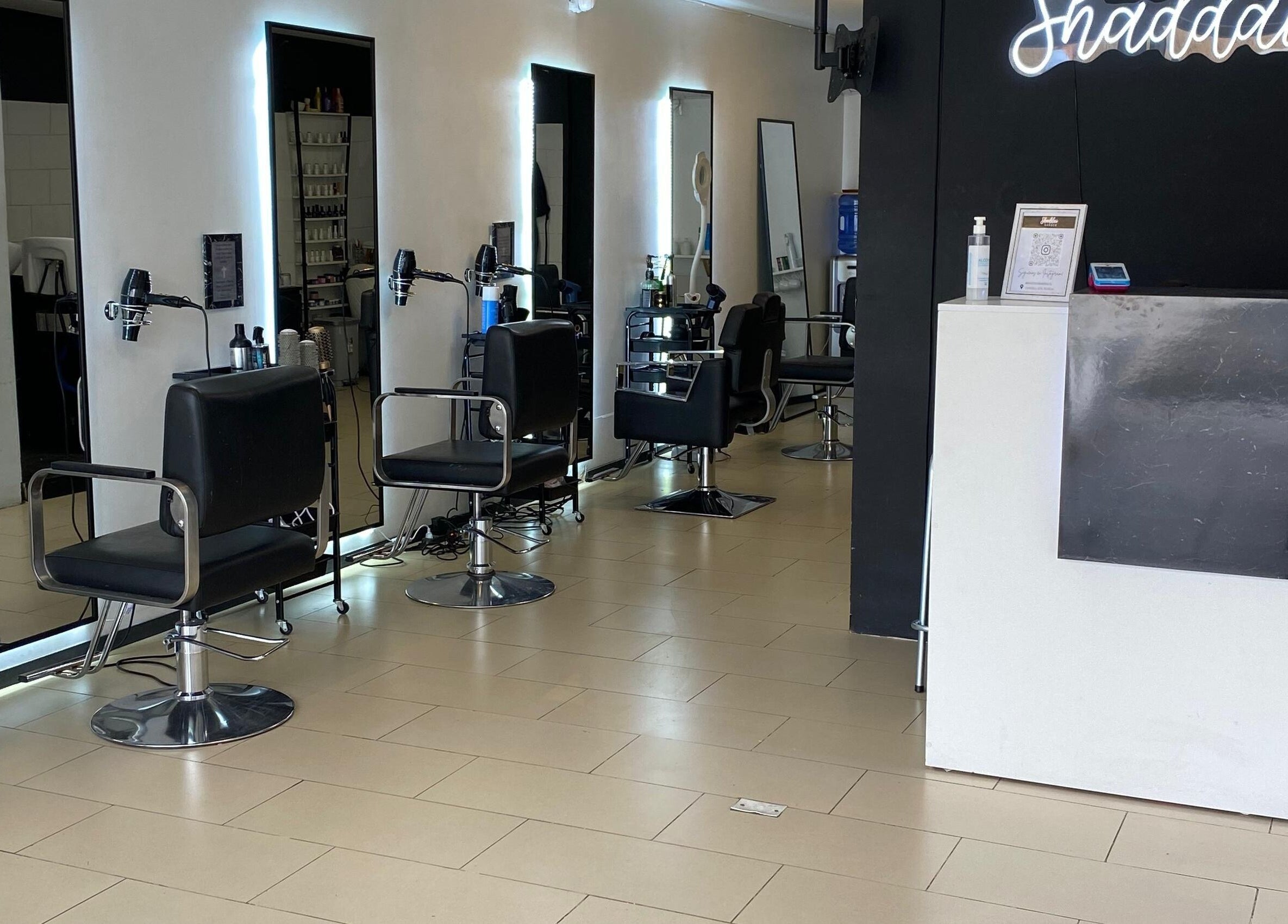 Interior moderno de Shaddai Salón de belleza y Barbería en Ñuñoa, Región Metropolitana, CL, con sillas de estilista.