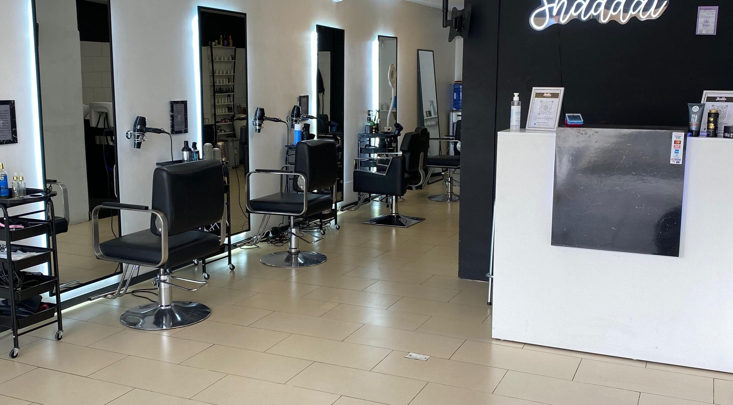 Interior moderno de Shaddai Salón de belleza y Barbería en Ñuñoa, Región Metropolitana, CL, con sillas de estilista.