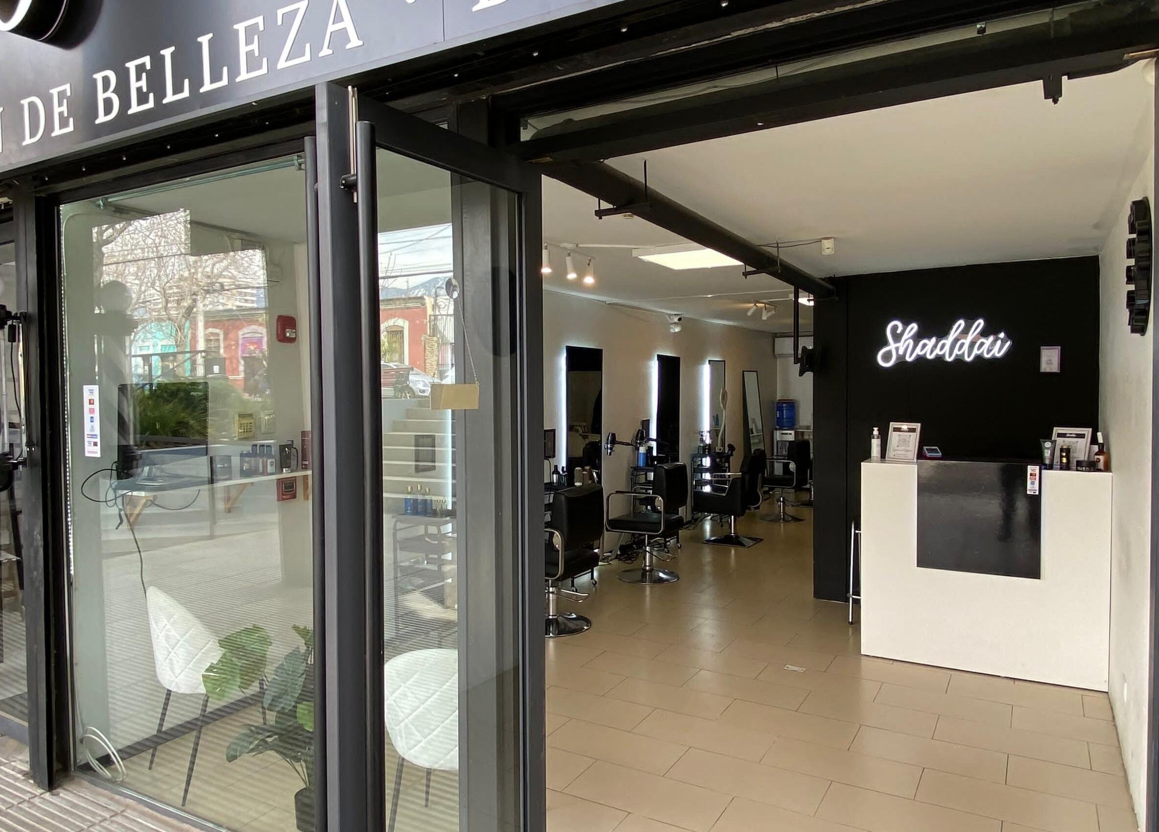 Entrada iluminada de Shaddai Salón de belleza y Barbería en Ñuñoa, Región Metropolitana, CL con interior moderno.