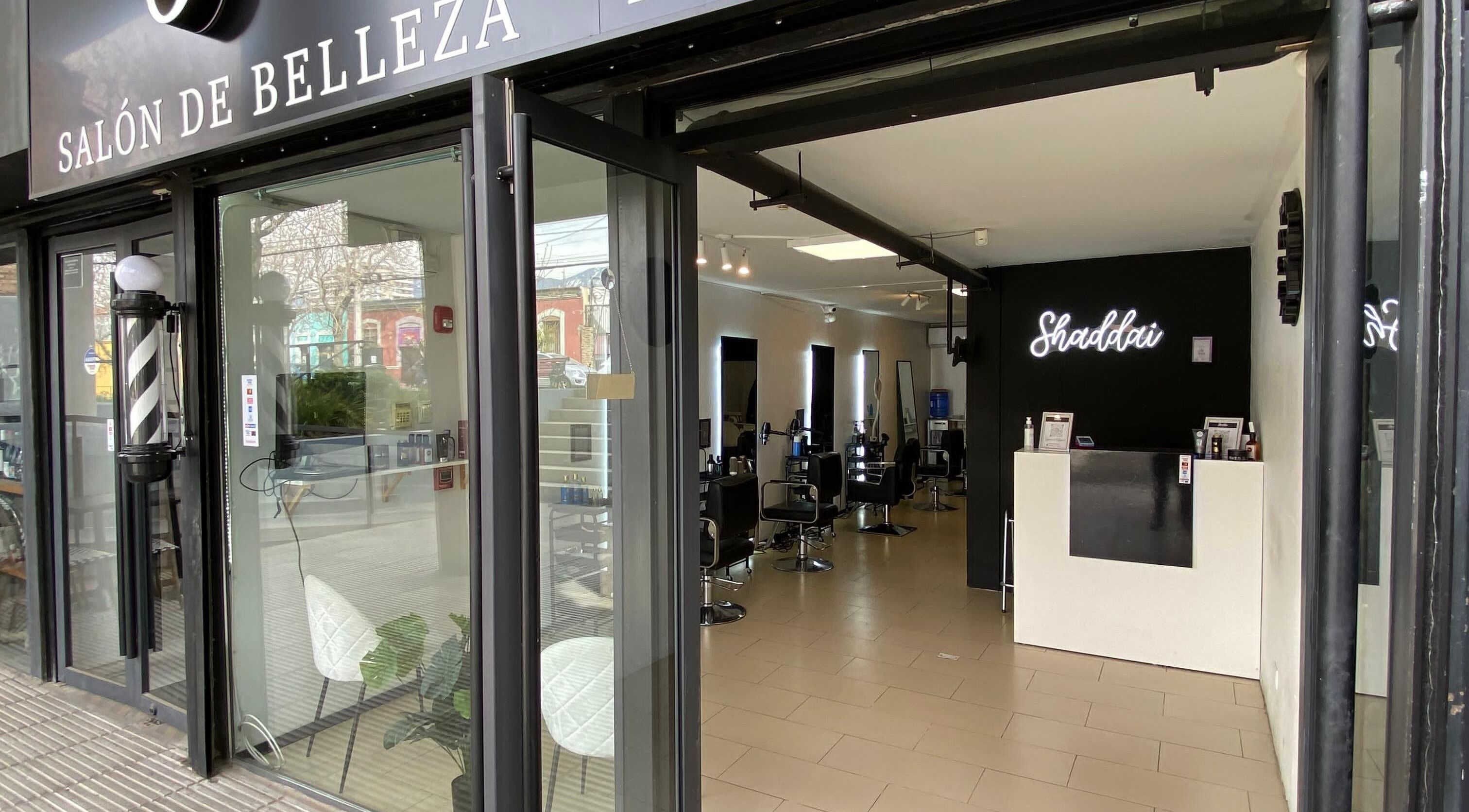 Entrada iluminada de Shaddai Salón de belleza y Barbería en Ñuñoa, Región Metropolitana, CL con interior moderno.