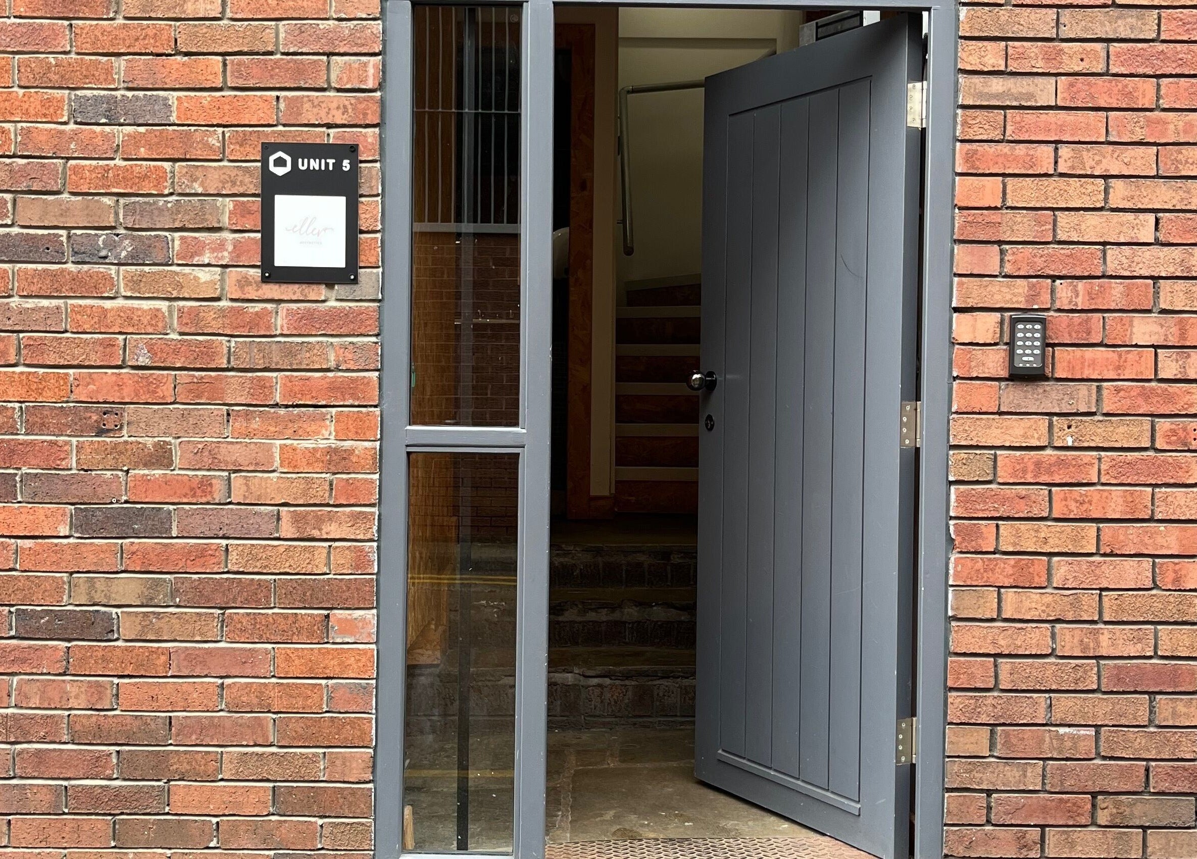 Entrance to Polished by Grace located at Barnsley, England, GB with an open grey door and brick facade.