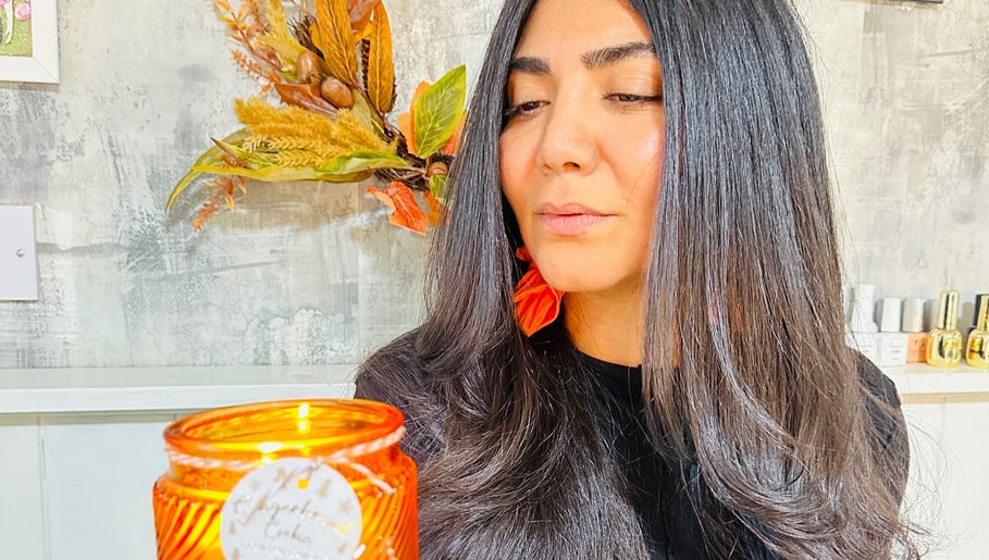 Warm ambiance at Siin Hair Beauty, Nottingham, England, GB, featuring a client with sleek hair and a glowing candle.