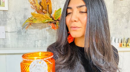 Warm ambiance at Siin Hair Beauty, Nottingham, England, GB, featuring a client with sleek hair and a glowing candle.