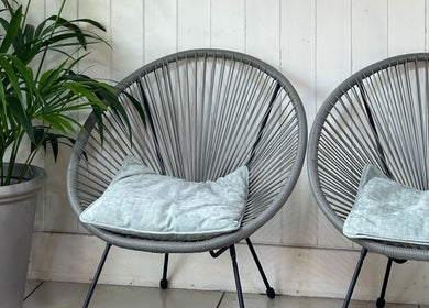 Stylish seating area at Siin Hair Beauty, Nottingham, England, GB with modern chairs and a lush plant.
