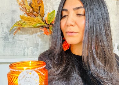 Woman with sleek hair holding candle at Siin Hair Beauty, Nottingham, England, GB.