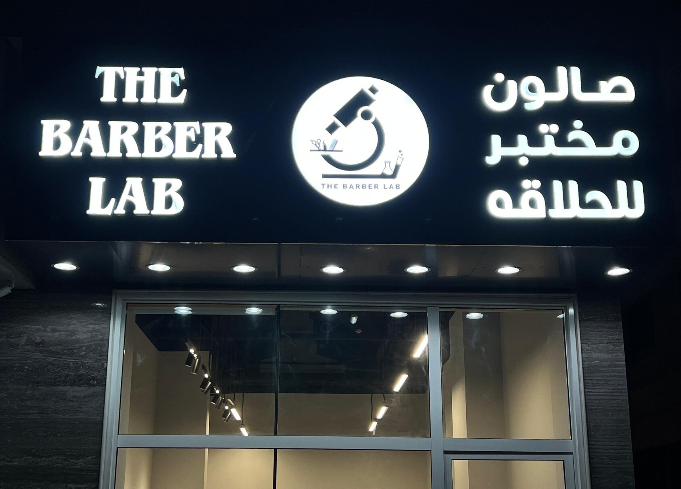 Illuminated sign of The Barber Lab, Sharjah, Sharjah, AE at night.