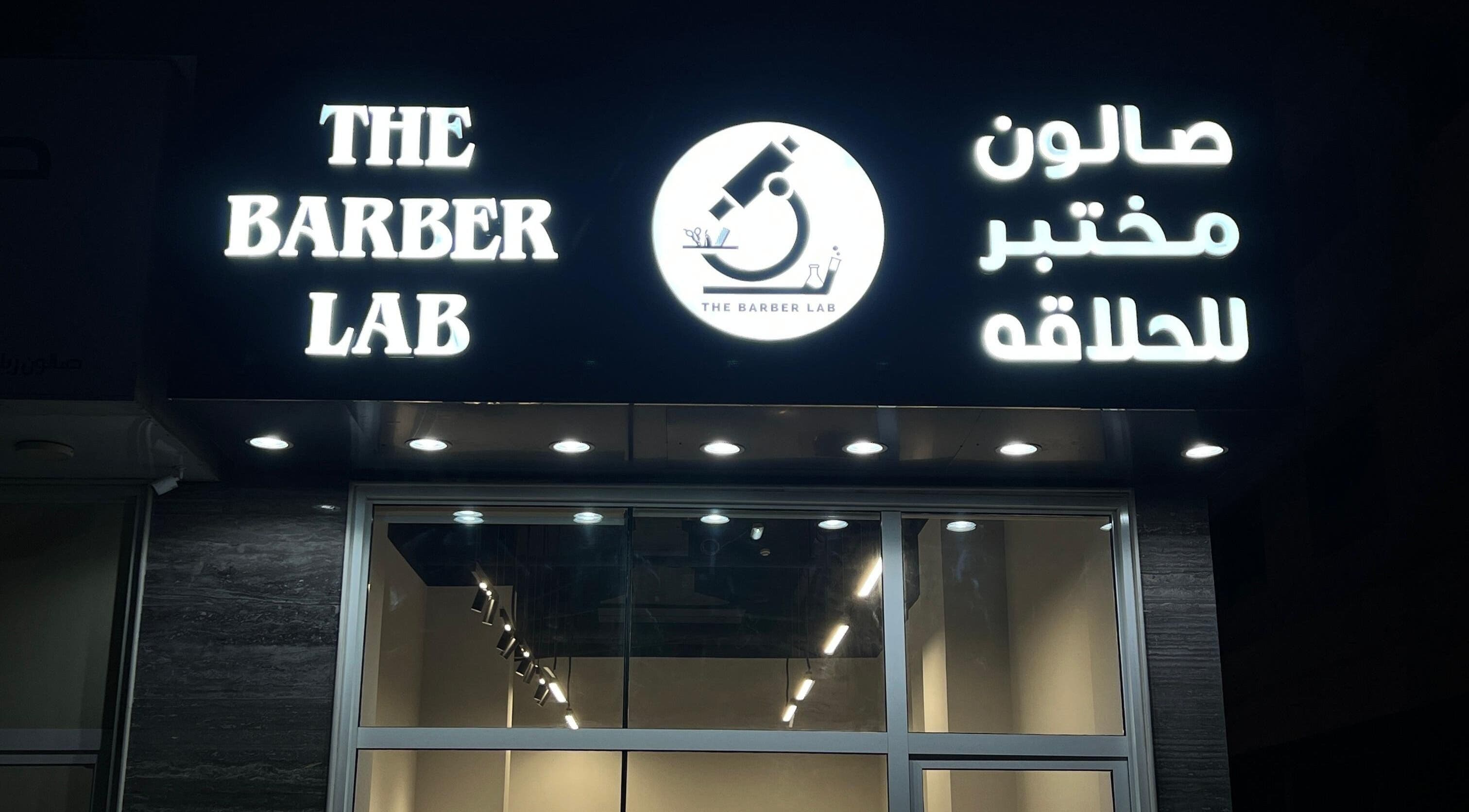 Illuminated sign of The Barber Lab, Sharjah, Sharjah, AE at night.