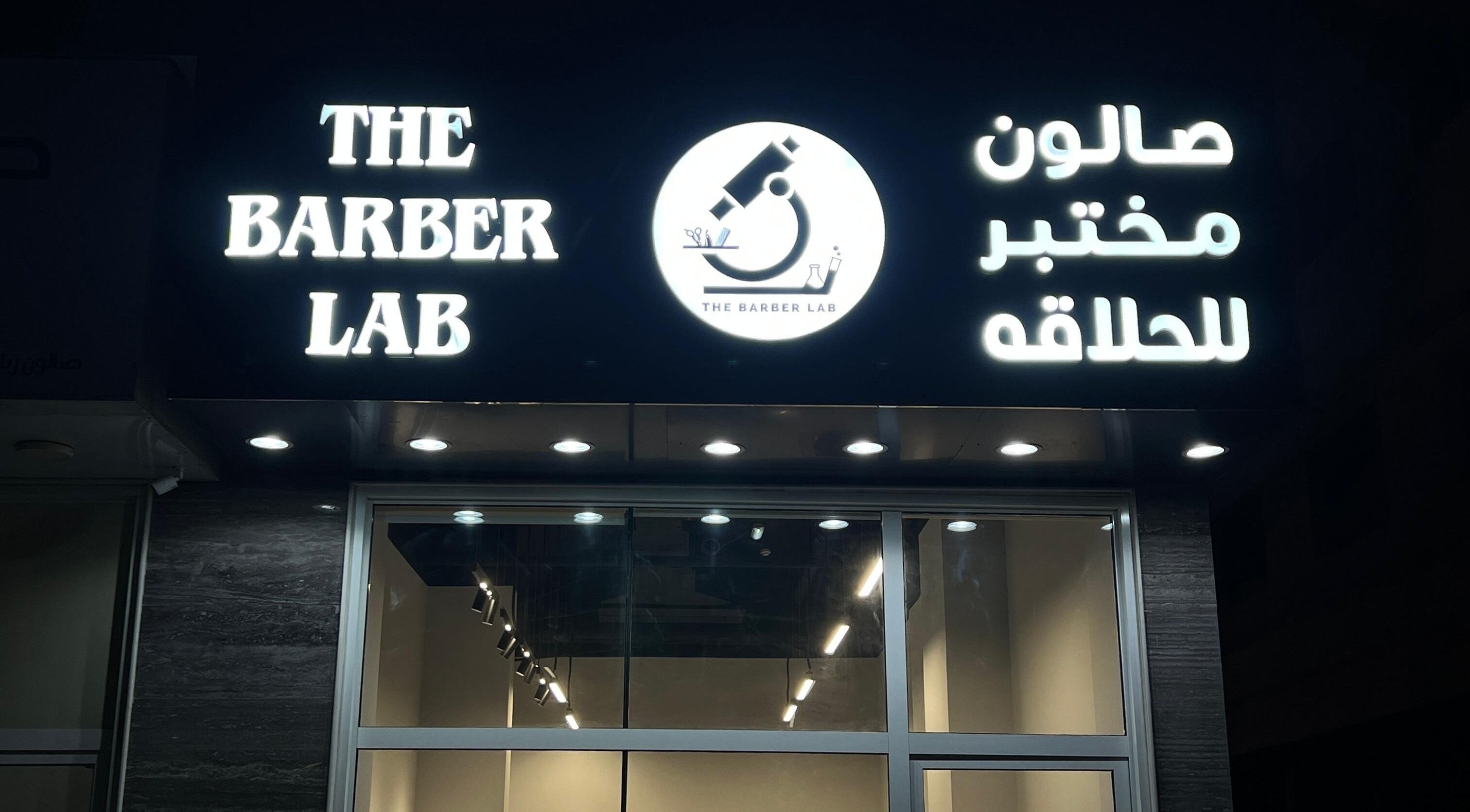 Illuminated sign of The Barber Lab, Sharjah, Sharjah, AE at night.