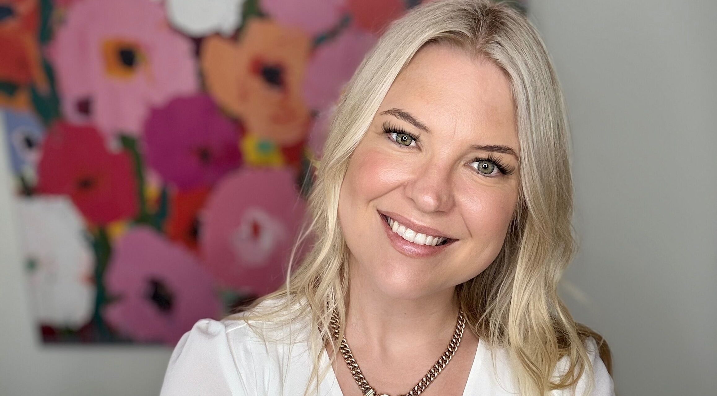 Smiling individual at Magnetic Glow, Redcliffe, Queensland, AU with floral art background.