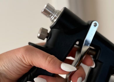Close-up of hand with white nails holding a beauty tool at Magnetic Glow, Redcliffe, Queensland, AU.