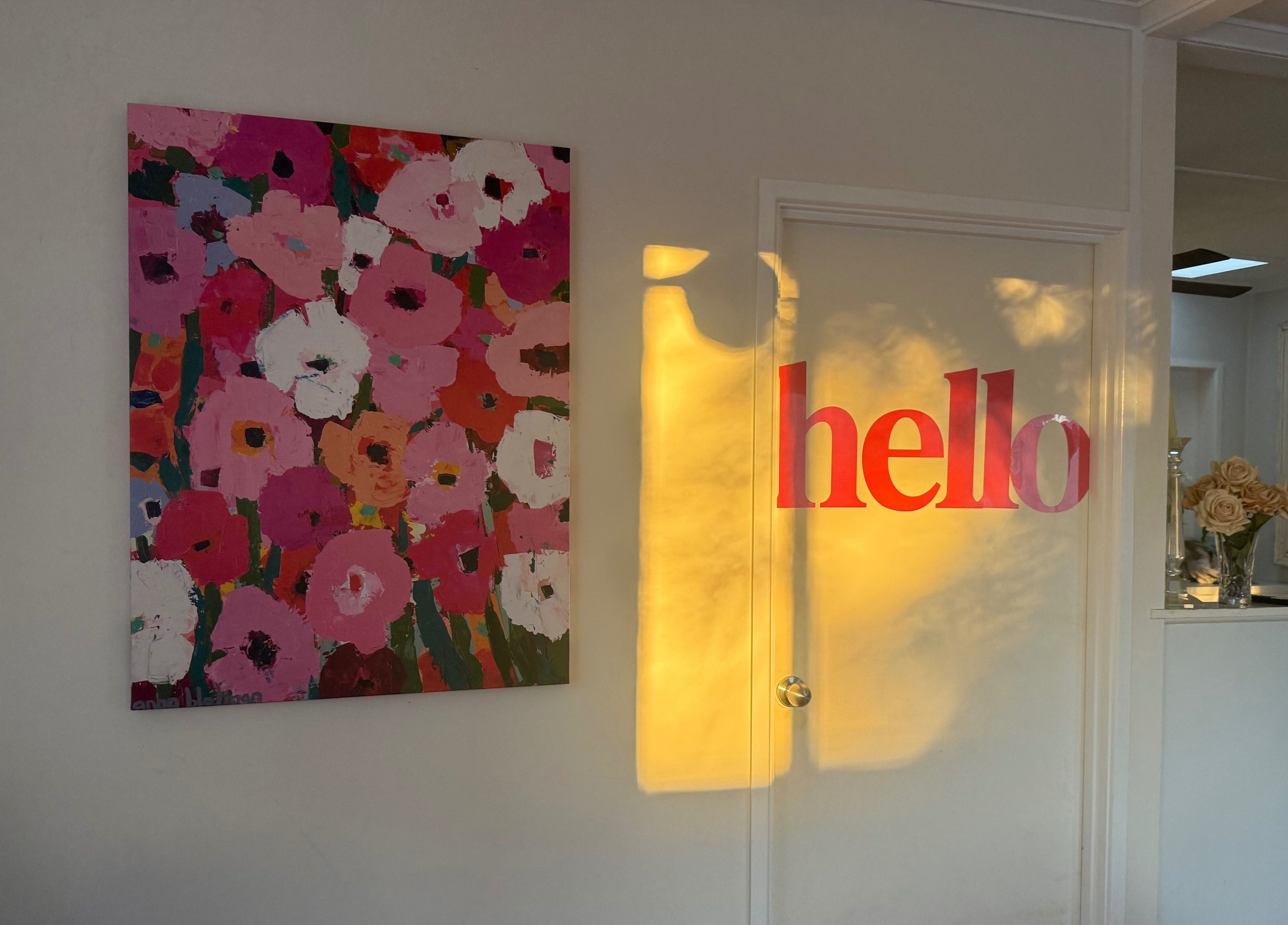 Vibrant floral painting and 'hello' sign at Magnetic Glow, Redcliffe, Queensland, AU.