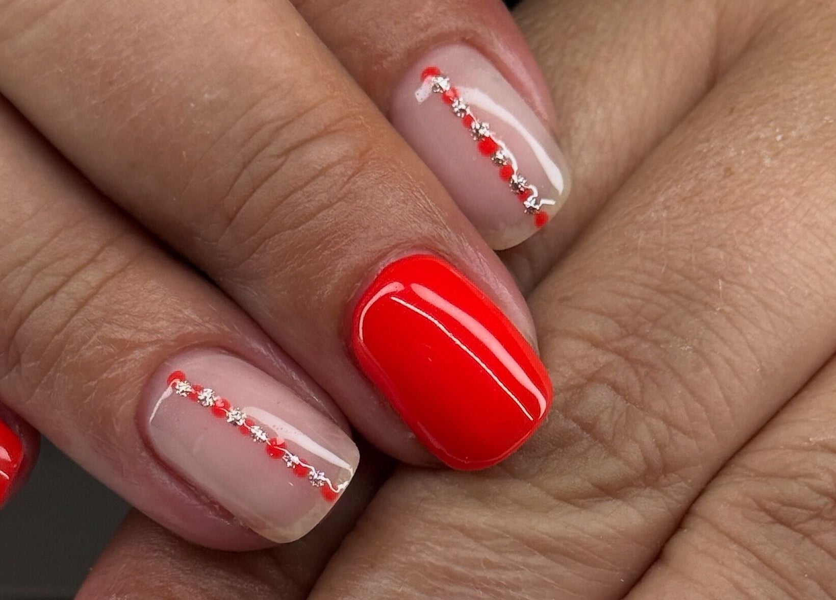 Artistic red and nude manicure at Polished by Kate, Constantine, England, GB, showcasing delicate nail art design.