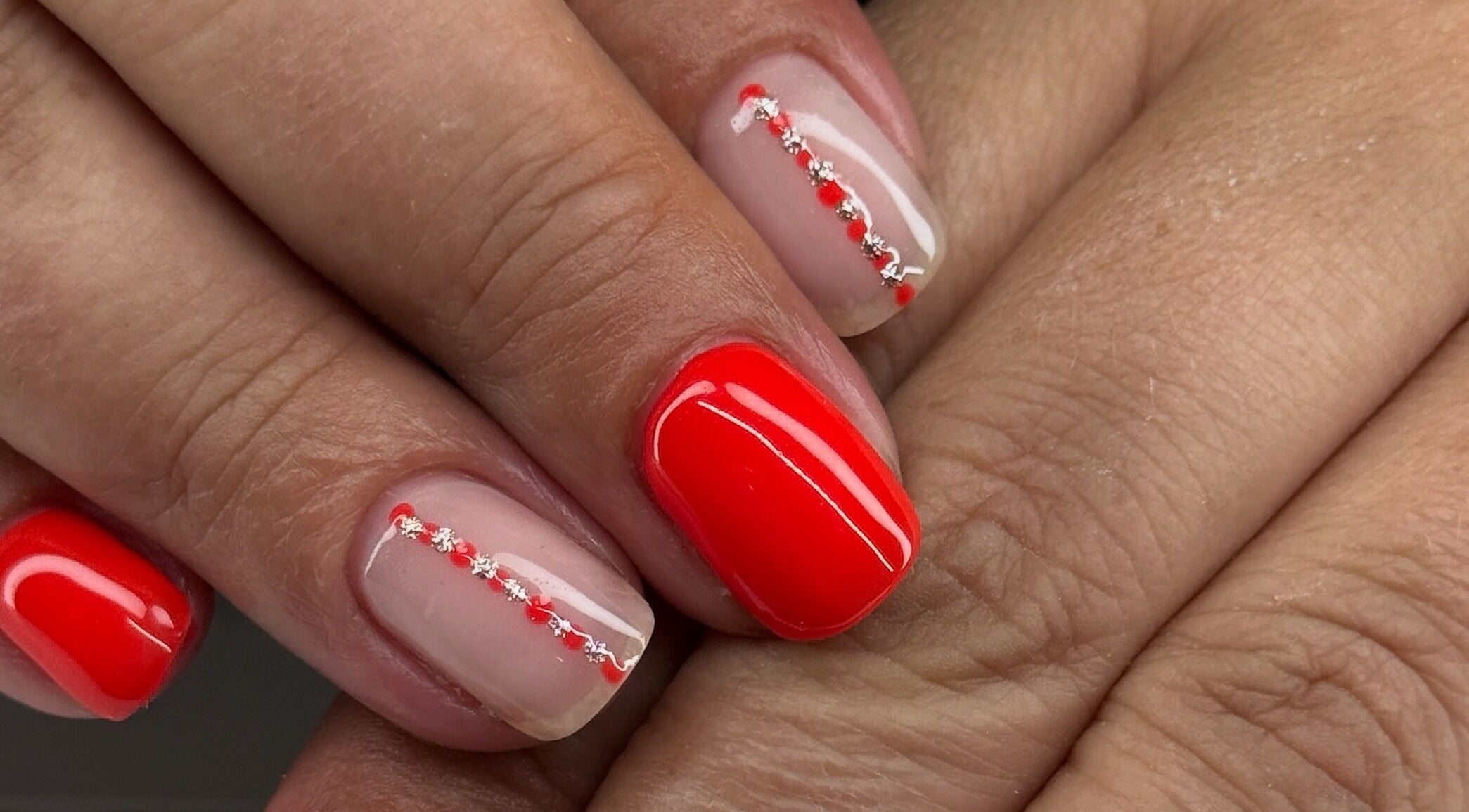 Artistic red and nude manicure at Polished by Kate, Constantine, England, GB, showcasing delicate nail art design.